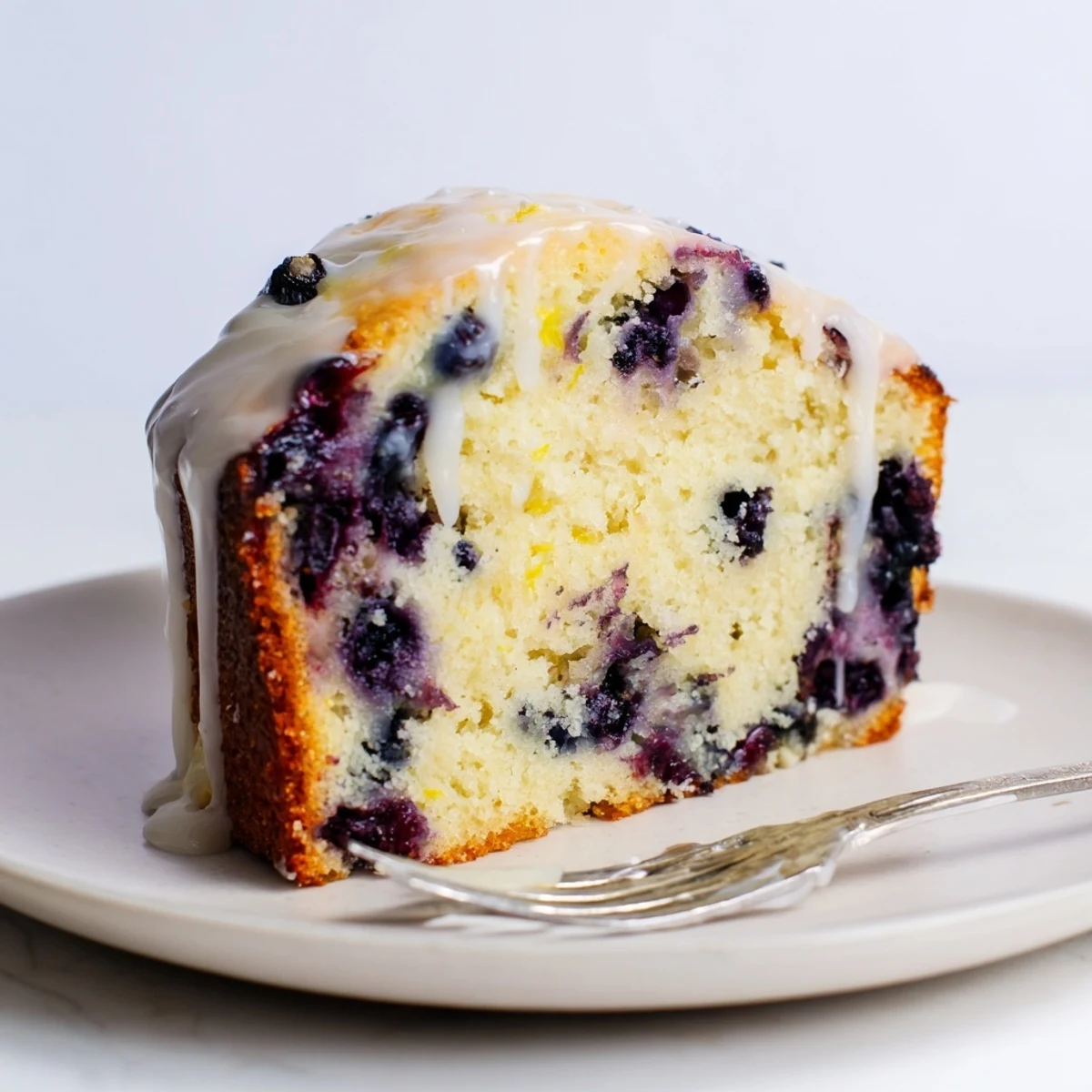 Moist blueberry lemon pancake bread topped with a sweet glaze, perfect for breakfast.