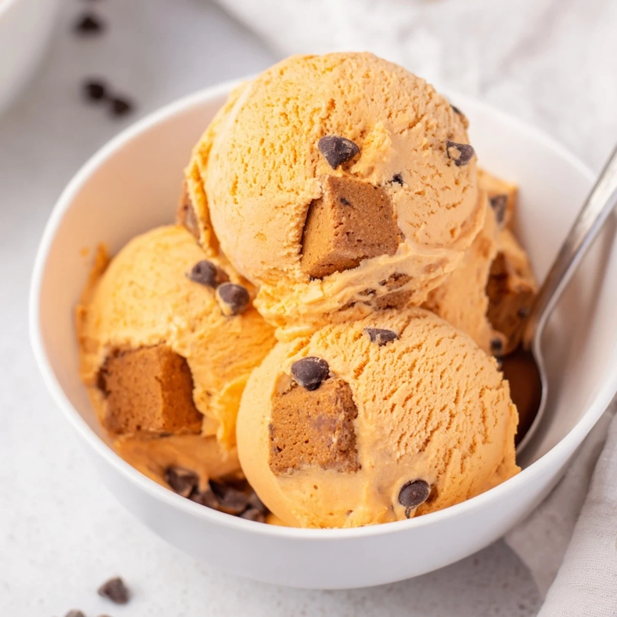Creamy Pumpkin Chocolate Chip Muffin Ice Cream topped with muffin pieces and chocolate chips.  