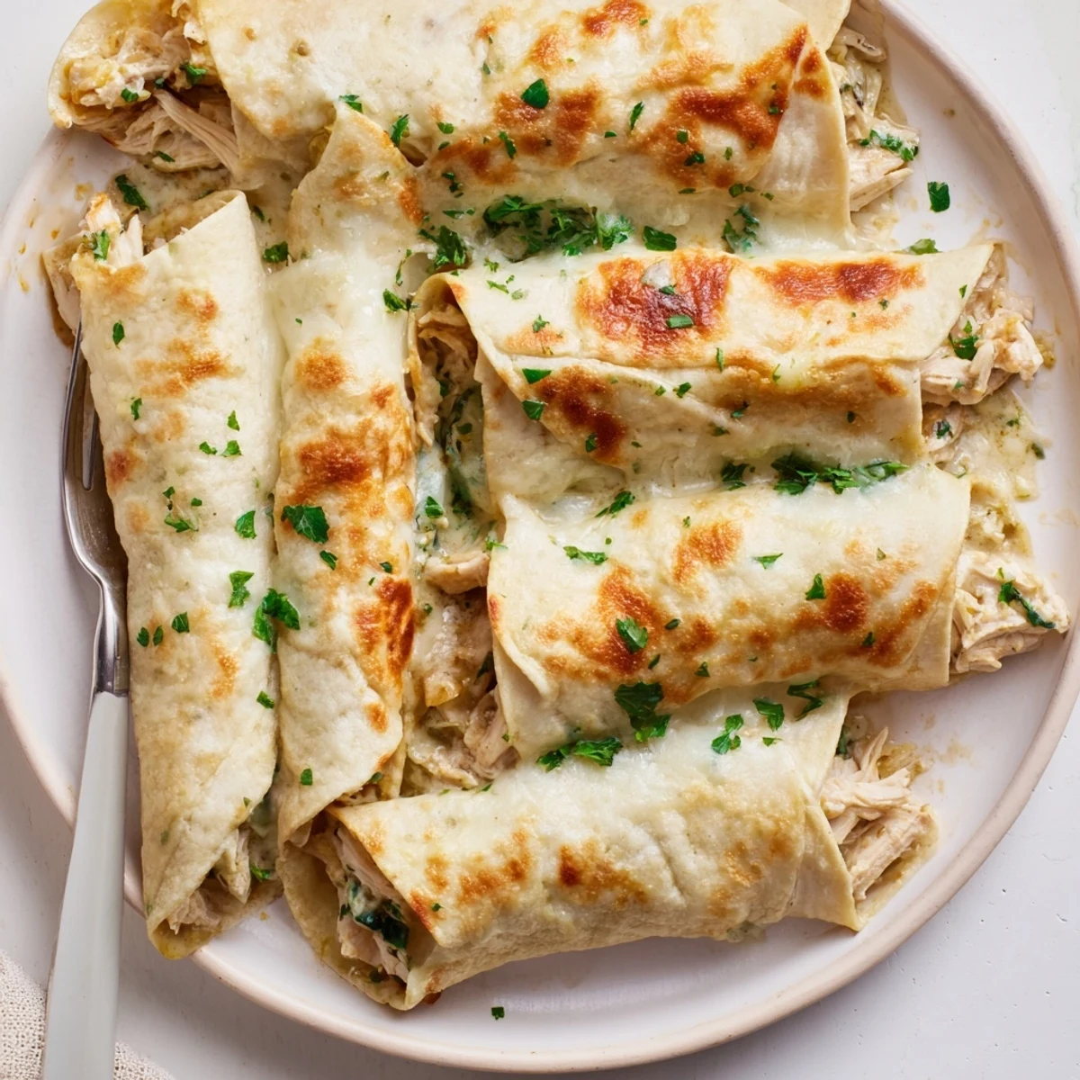 Satisfying Chicken Alfredo Tortilla Bake layered with tender chicken and fresh spinach.