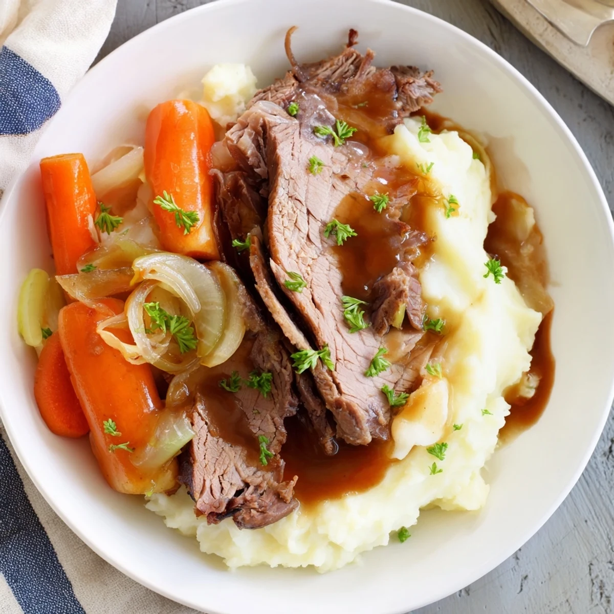 Tender beef pot roast with carrots, celery, and rich gravy over buttery mashed potatoes.  