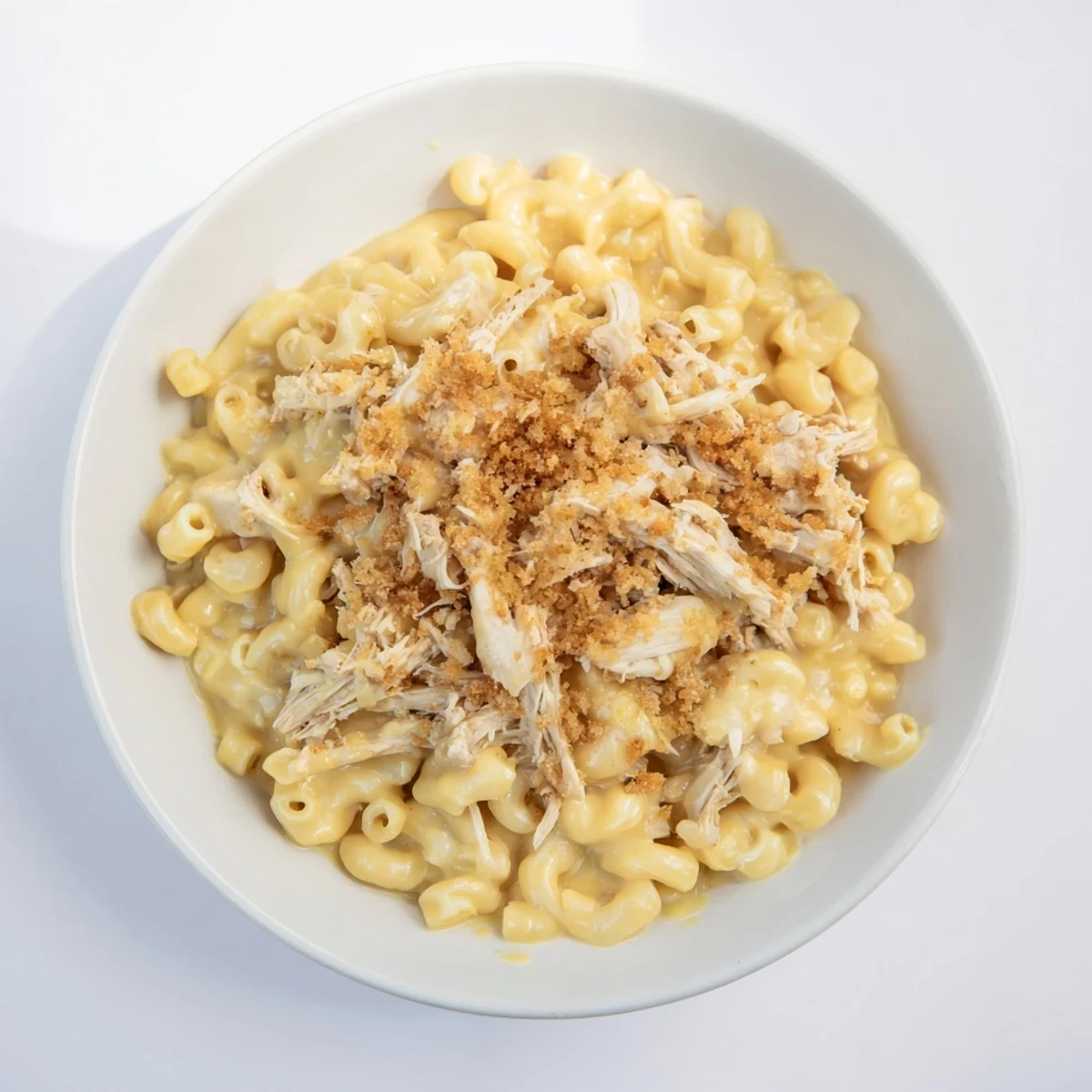 A bubbling baking dish overflowing with golden Classic Mac & Cheese with BBQ Chicken, ready to eat.