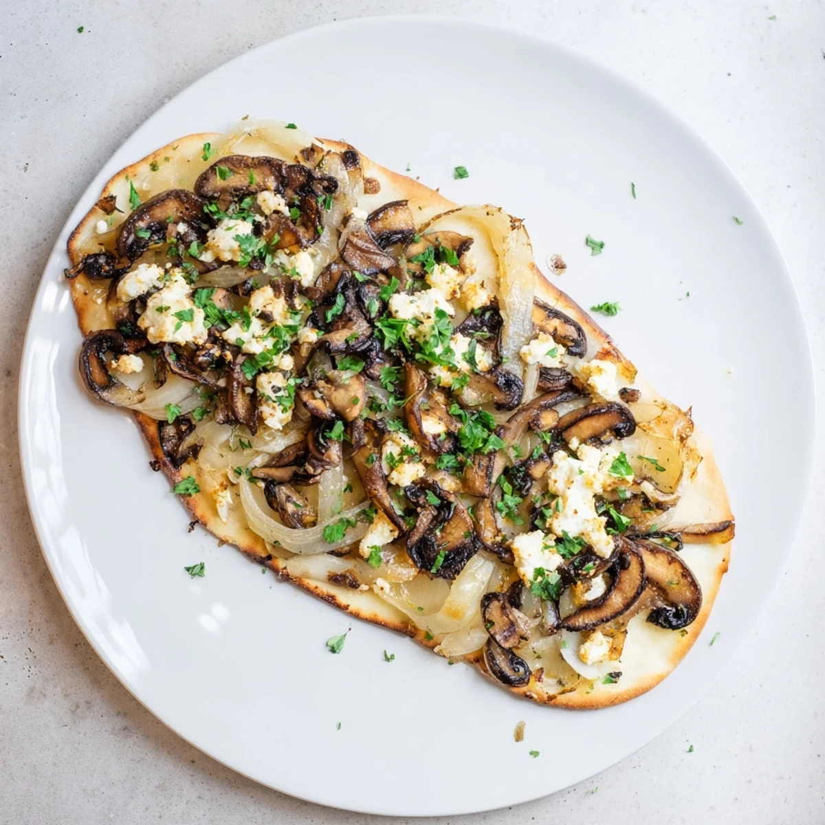 Warm Caramelized Onion & Mushroom Flatbread, topped with melted cheese, ready to eat.
