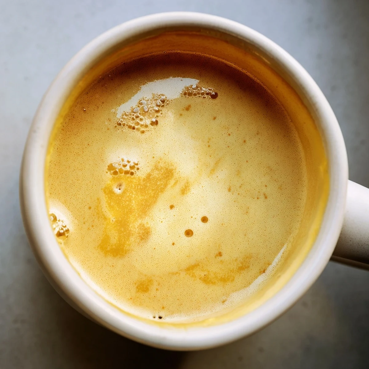 A steaming Onion Latte with a swirl of milk foam, offering savory caramelized onion notes.