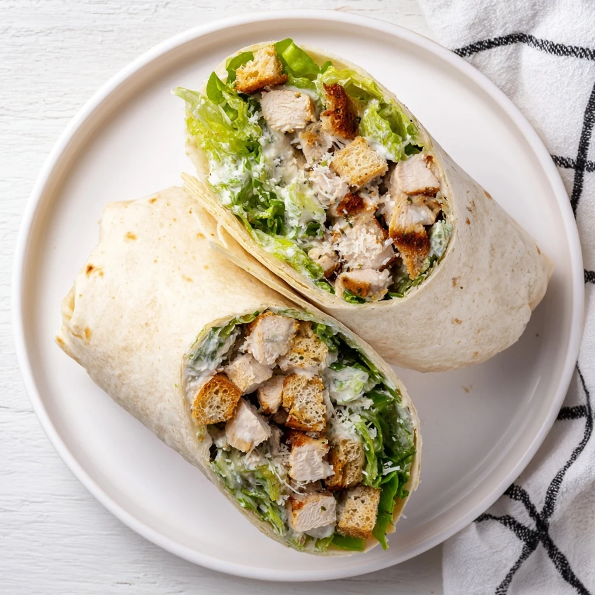Golden-brown Chicken Caesar Wraps, cut in half, revealing the fresh romaine lettuce and chicken filling.