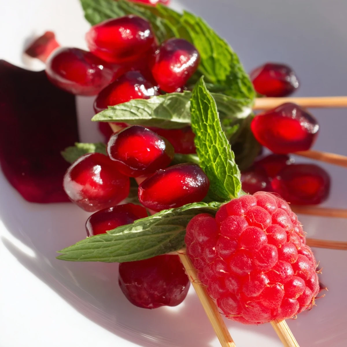 Beautifully arranged Midnight Baisers de Minuit, a French garnish with edible rose petals and mint.