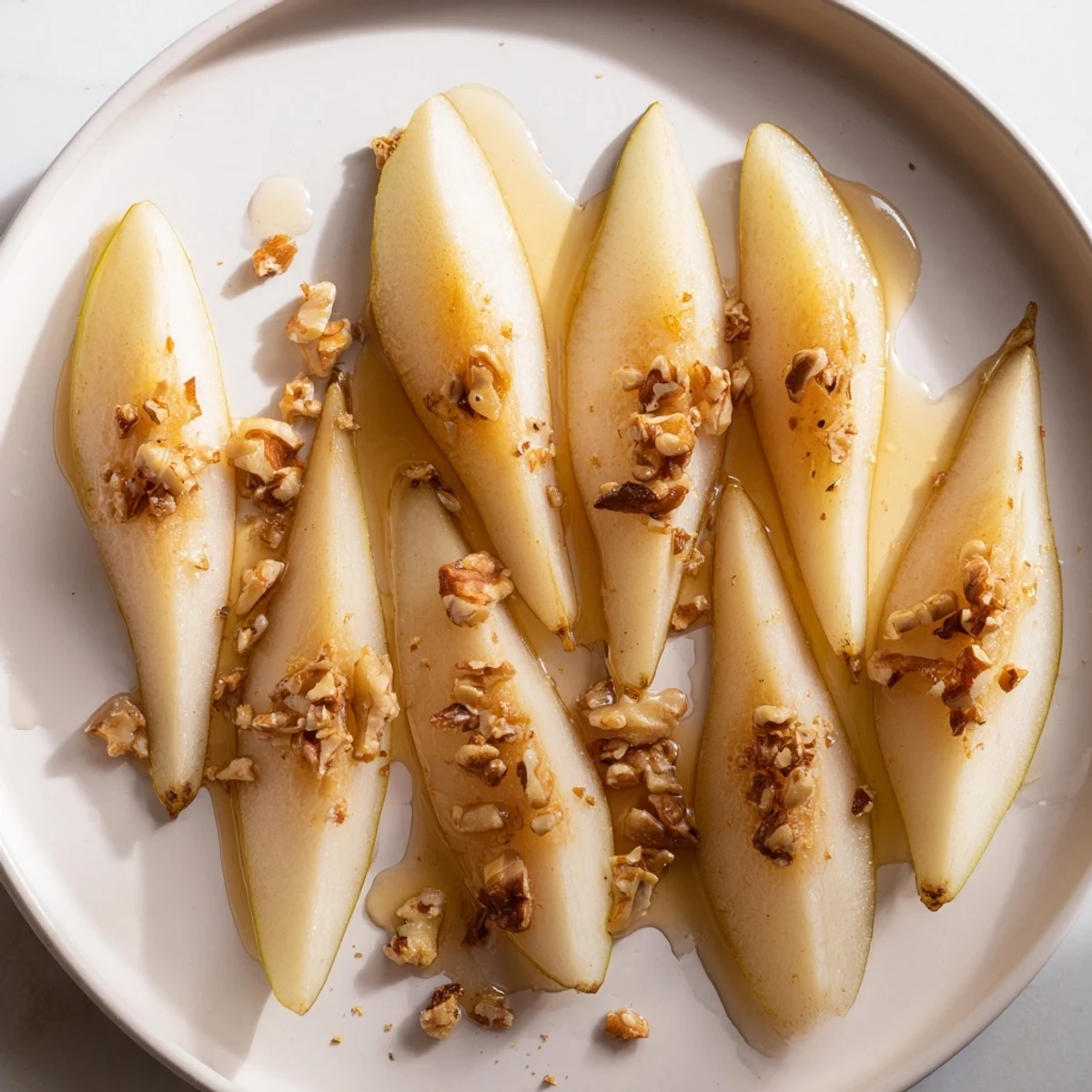 Fresh pear slices with golden honey drizzle, a simple and elegant dessert.