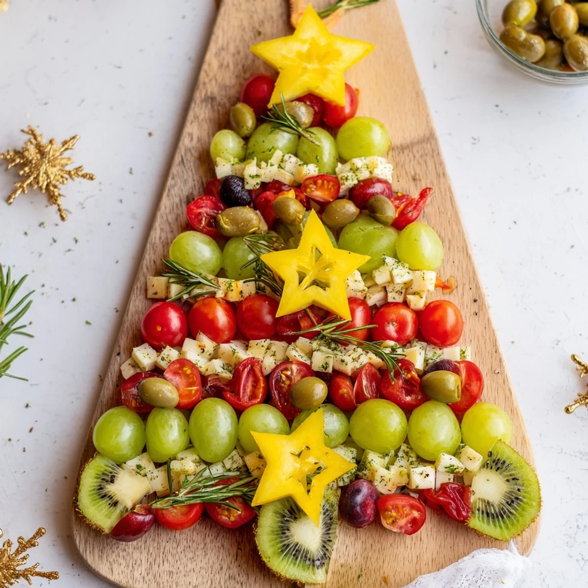 Festive Christmas Tree Triangle Board arranged with fruits and veggies, a delicious and easy vegetarian holiday appetizer for sharing.
