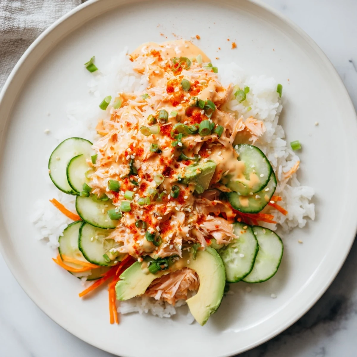 Enjoy this easy Spicy Canned Salmon Rice Bowl, packed with fresh veggies and a creamy sauce.
