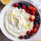 A close-up shot of the creamy, fluffy cream cheese fruit dip with fresh, colorful berries arranged around it.