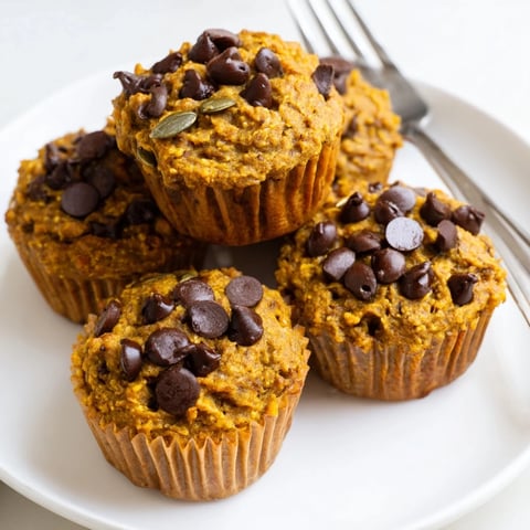 Moist Vegan Pumpkin Chocolate Chip Muffins topped with luscious chocolate chips and spices.  