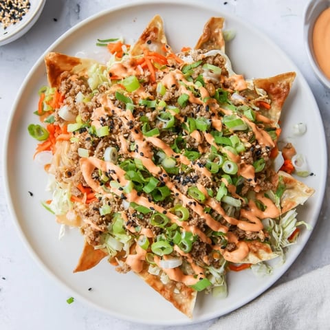 Crispy Japanese Gyoza Nachos topped with spicy sriracha mayo and vibrant veggies.  