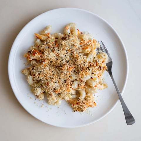 Creamy Spicy Kimchi Mac & Cheese topped with crunchy sesame, a fusion delight.  
