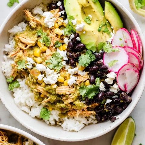 Vibrant Green Enchiladas Rice Bowl topped with fresh avocado and zesty lime wedges.