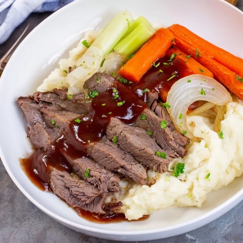 Hearty slow cooker pot roast served with creamy mashed potatoes and fresh herbs.  