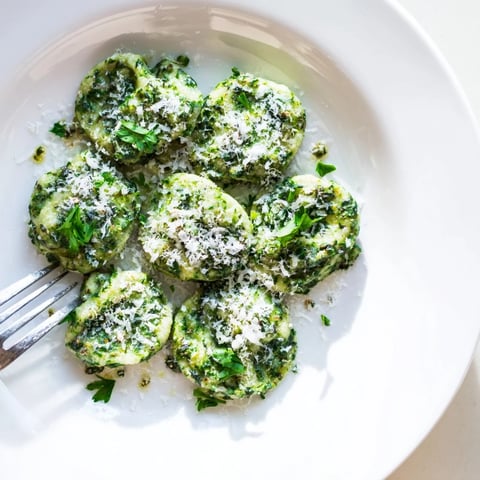 Tender spinach spaetzle with garlic butter, served warm for a comforting dish.  