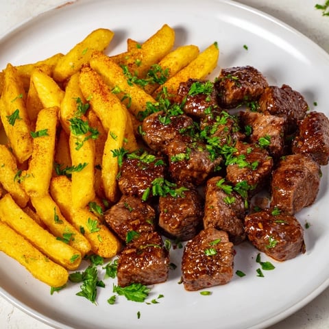 Golden-brown Blackened Cajun Steak Bites with perfectly cooked fries, ready to enjoy.