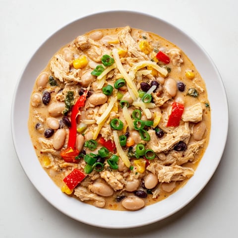A steaming bowl of slow cooker white chicken chili with black beans, topped with fresh cilantro.