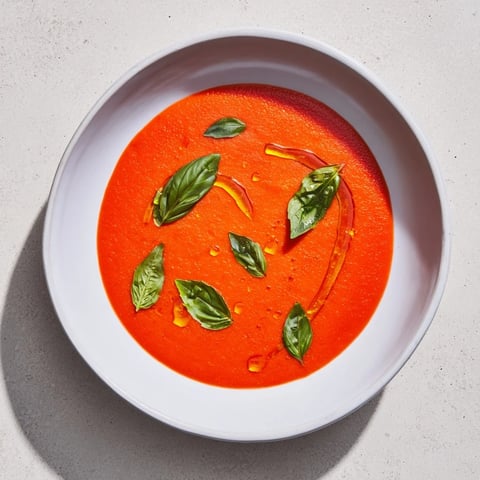 Spicy Tomato & Roasted Pepper Soup: steaming bowl of vibrant red soup, garnished with fresh basil.