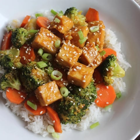 Crispy sesame tofu and broccoli, a delicious vegetarian meal served with fluffy white rice.