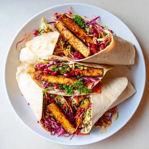 Sweet chili tofu crunch wrap with glistening tofu, colorful holiday slaw, and crispy tortilla chips.