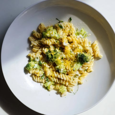 Creamy Green Goddess Broccoli Cheddar One-Pot Pasta with vibrant herbs and melted cheddar cheese visually enticing.