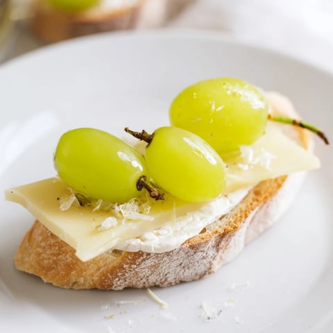 Close-up of Sparkling Champagne Toast: Glistening, golden grapes top creamy cheese, a celebratory appetizer.