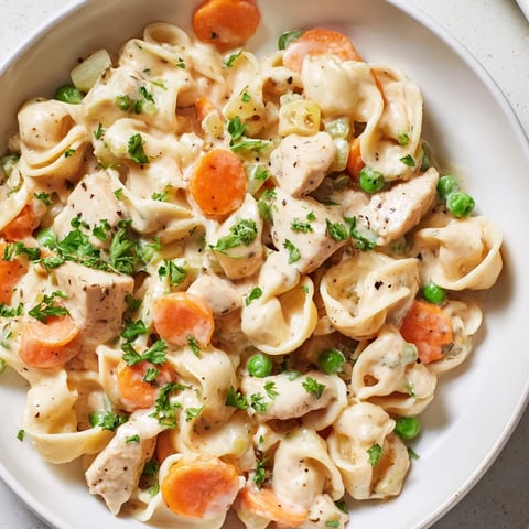 Steaming creamy chicken and egg noodles, a hearty American dinner with fragrant herbs and veggies.